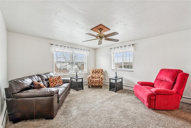 living area featuring a textured ceiling, carpet floors, ceiling fan, and a baseboard heating unit