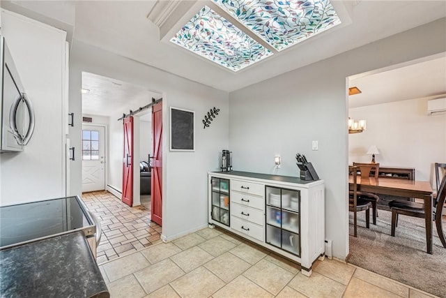 kitchen featuring a barn door, range with electric cooktop, a baseboard radiator, stainless steel microwave, and an inviting chandelier