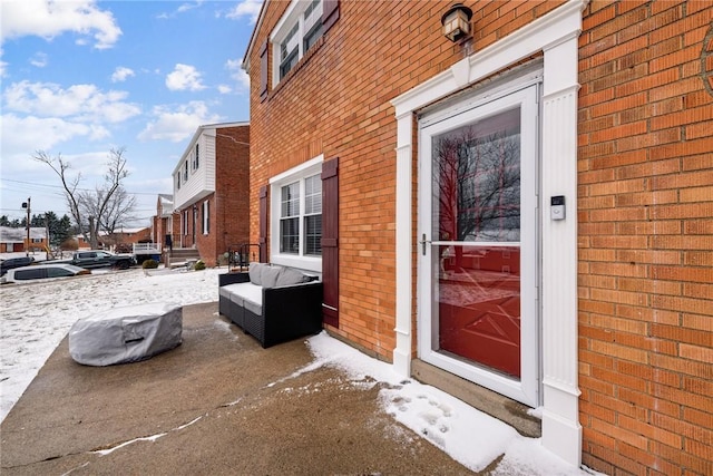 property entrance featuring an outdoor hangout area and brick siding