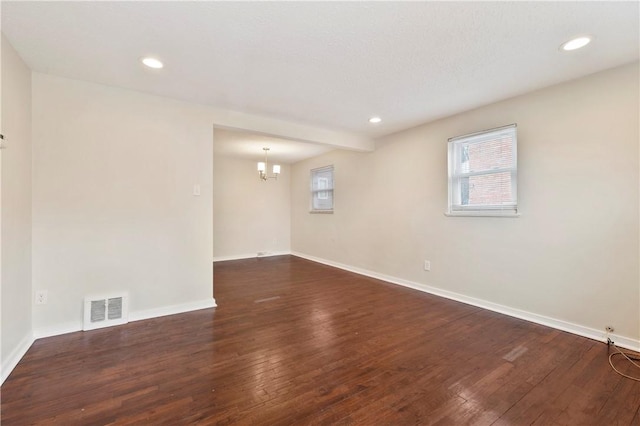 spare room featuring dark wood-style floors, baseboards, visible vents, and recessed lighting