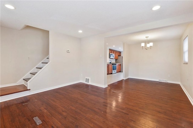 unfurnished living room with dark wood-style floors, recessed lighting, visible vents, stairway, and baseboards