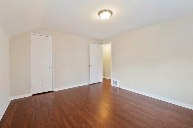 unfurnished bedroom featuring wood-type flooring, visible vents, and baseboards