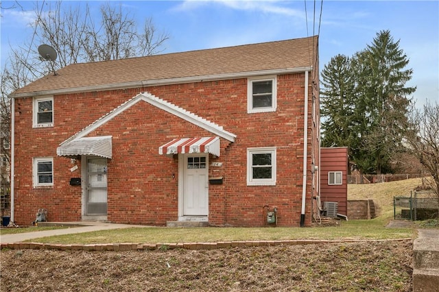 view of front of house with a front yard, fence, and brick siding