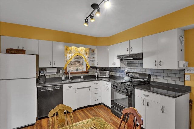 kitchen featuring open shelves, dark countertops, a sink, under cabinet range hood, and black appliances