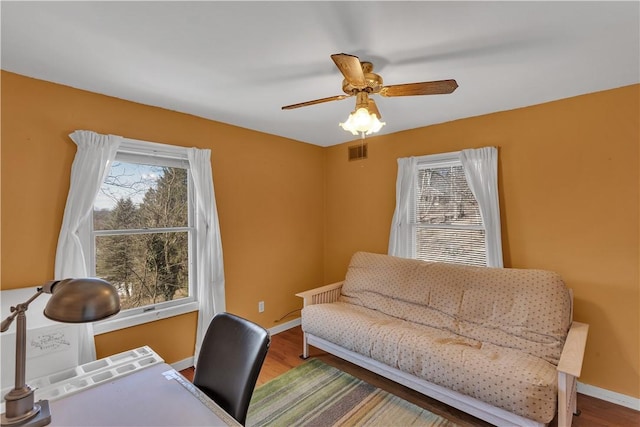 office space with ceiling fan, wood finished floors, visible vents, and baseboards