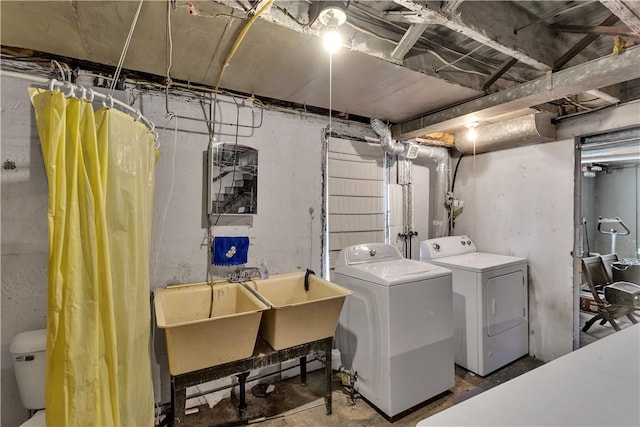 clothes washing area featuring washing machine and dryer, laundry area, and a sink