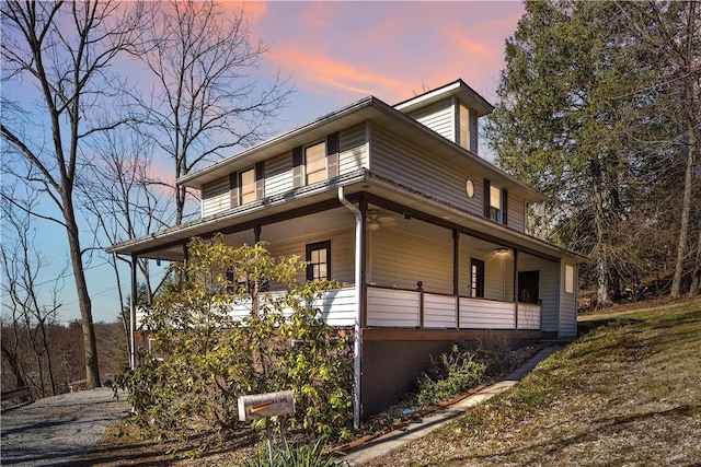 view of side of home featuring covered porch and ceiling fan