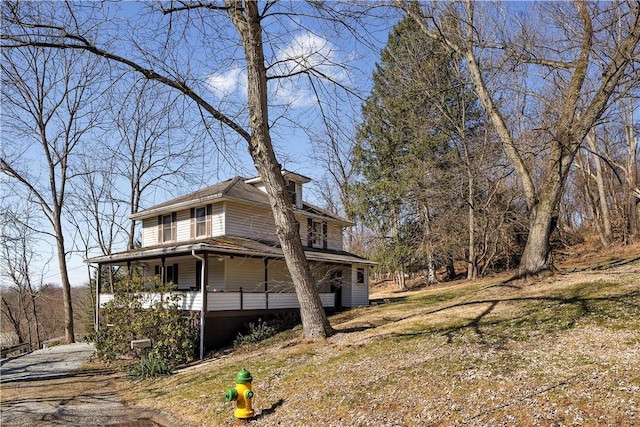 view of side of property featuring covered porch