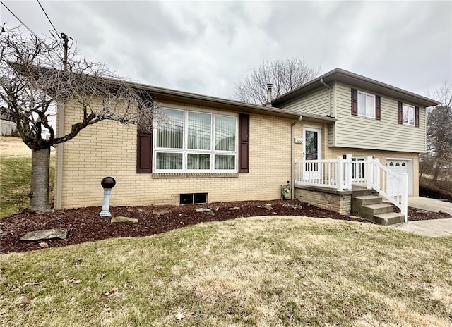 split level home with a front yard, brick siding, and an attached garage