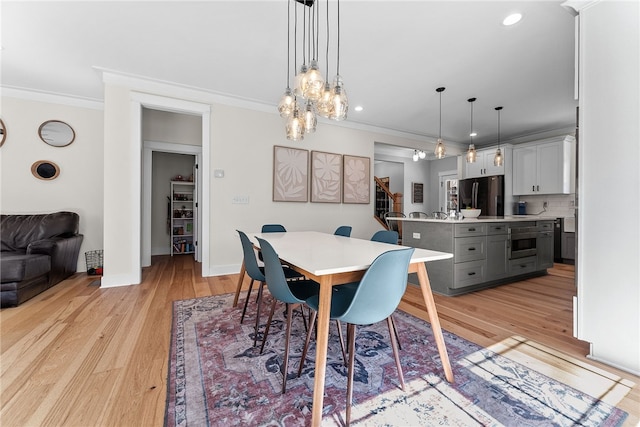 dining room featuring crown molding, recessed lighting, light wood-style floors, and baseboards