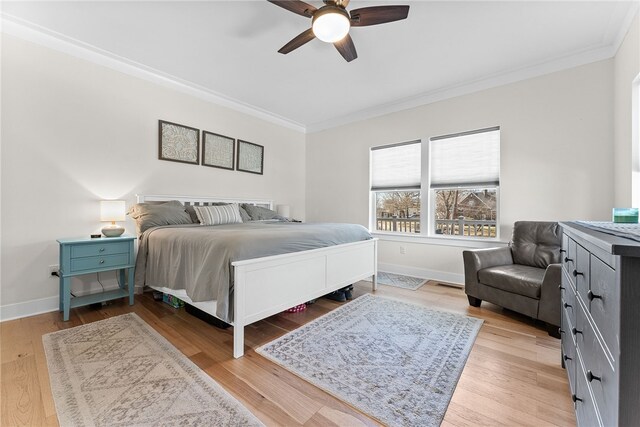 bedroom with ceiling fan, baseboards, crown molding, and light wood-style floors