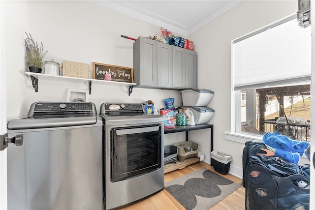 laundry room with washer and dryer, cabinet space, crown molding, light wood finished floors, and baseboards