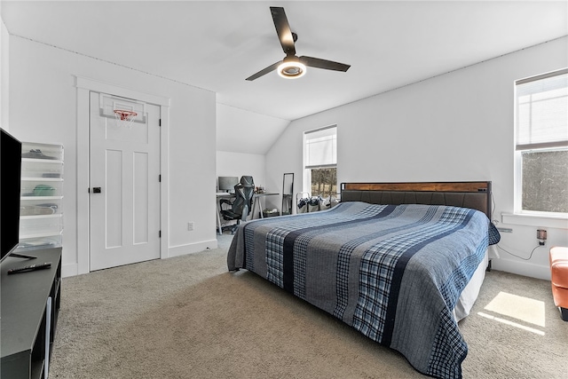 carpeted bedroom with vaulted ceiling, a ceiling fan, and baseboards