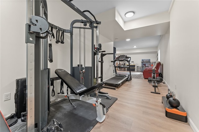 exercise area with baseboards and wood finished floors