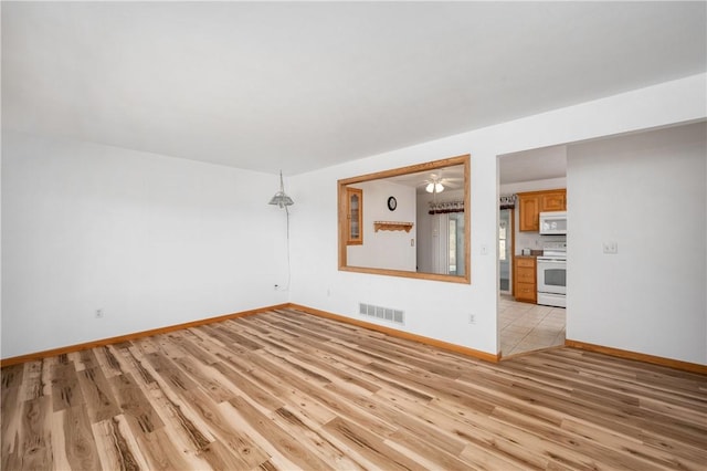 unfurnished room featuring light wood-type flooring, baseboards, and visible vents