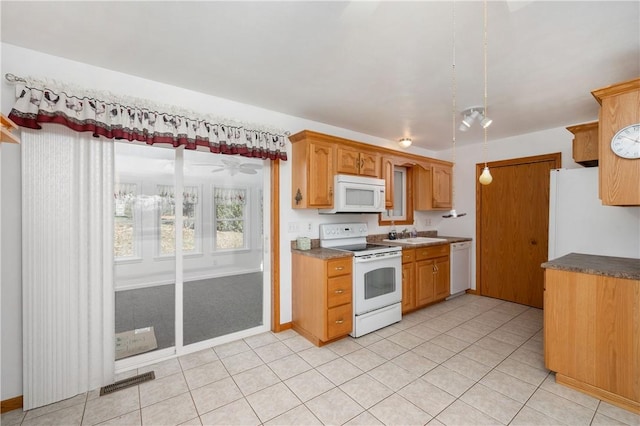 kitchen with white appliances, light tile patterned floors, baseboards, visible vents, and a sink