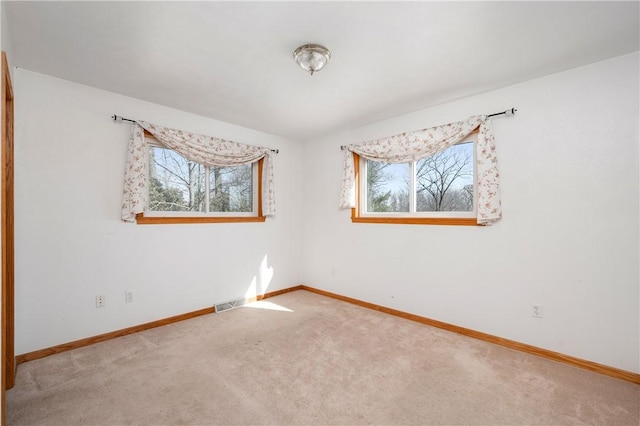 carpeted spare room with baseboards and a healthy amount of sunlight