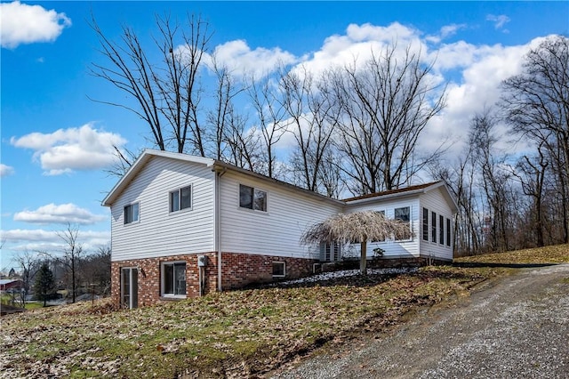 view of side of property with a sunroom and brick siding