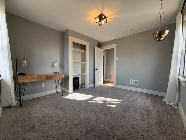 interior space with a closet, baseboards, visible vents, and carpet floors