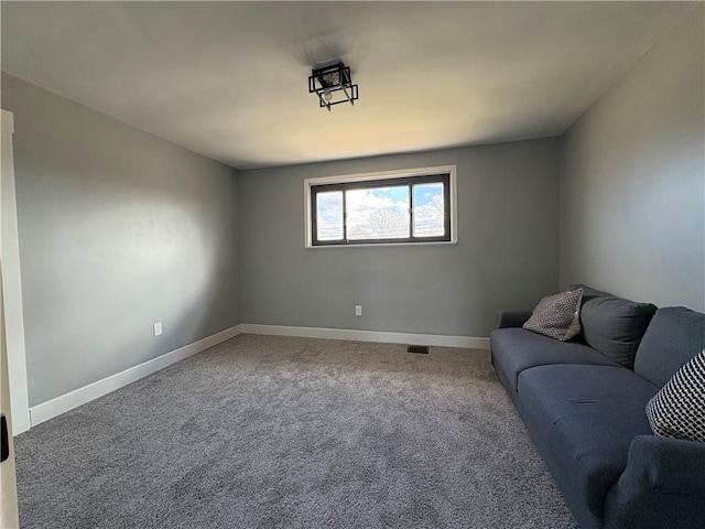 unfurnished living room featuring carpet flooring and baseboards