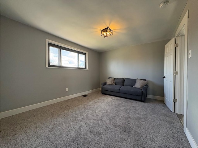 carpeted living area featuring visible vents and baseboards