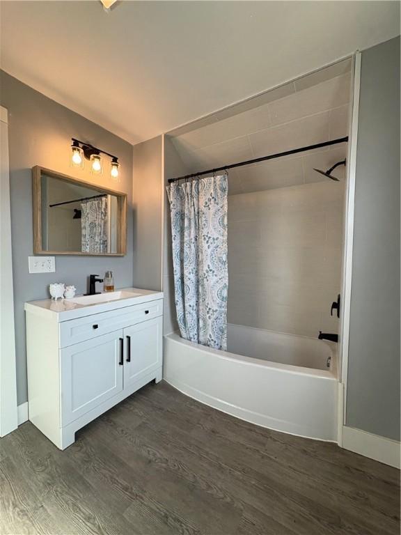 bathroom with vanity, shower / bathtub combination with curtain, and wood finished floors