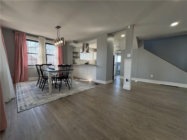 unfurnished dining area with dark wood-style floors, visible vents, an inviting chandelier, and baseboards