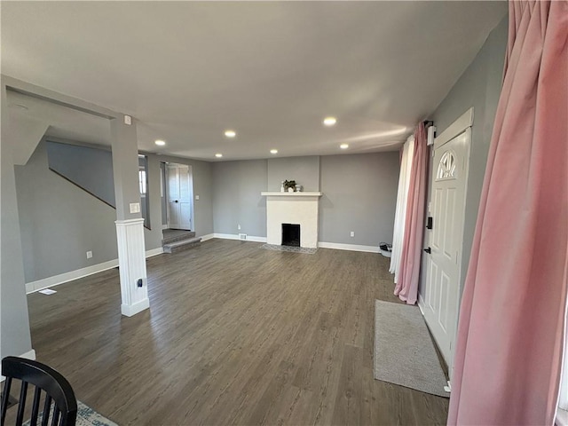 living area featuring dark wood finished floors, a fireplace with flush hearth, recessed lighting, and baseboards