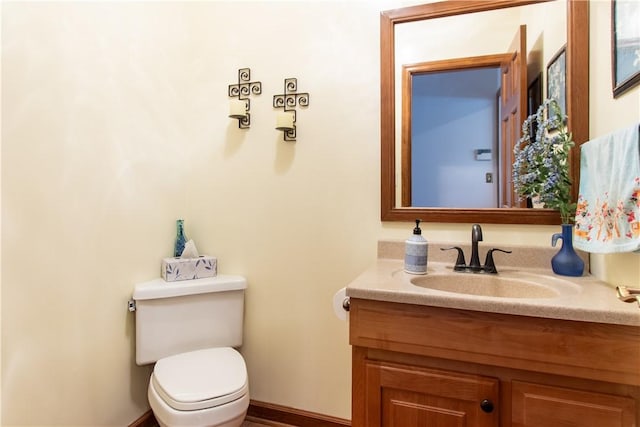 bathroom featuring vanity, toilet, and baseboards