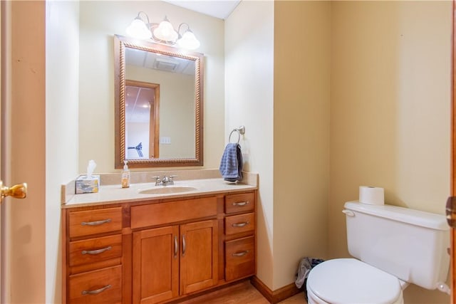 bathroom with baseboards, vanity, and toilet