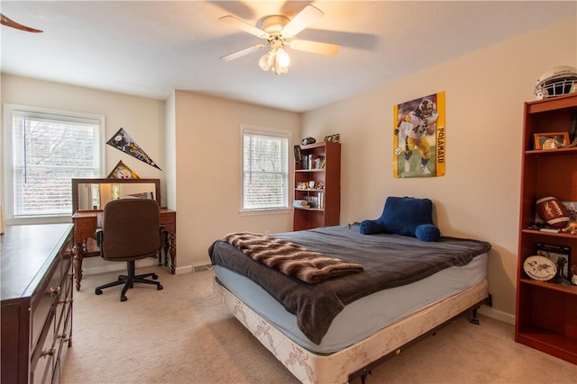 bedroom with light carpet, ceiling fan, and baseboards