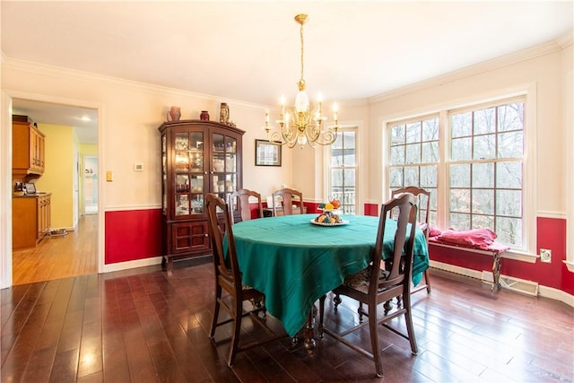 dining area featuring a notable chandelier, baseboards, dark wood finished floors, and crown molding