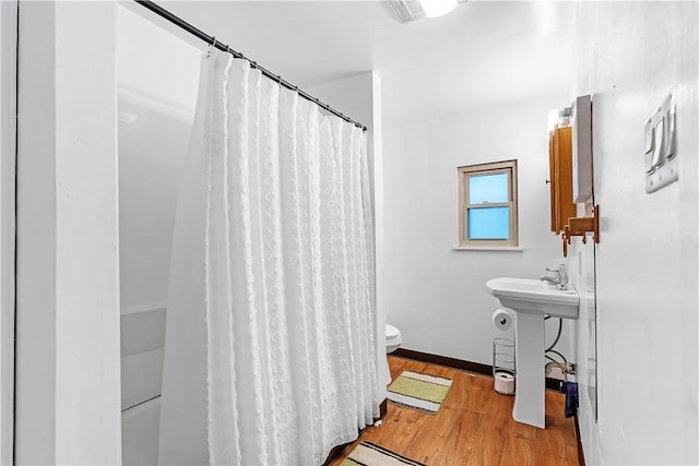 full bathroom featuring a sink, wood finished floors, toilet, and a shower with curtain