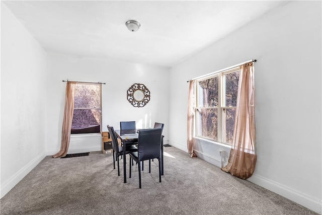 dining area with a wealth of natural light, carpet, visible vents, and baseboards