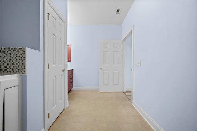 hall with light floors, baseboards, and visible vents