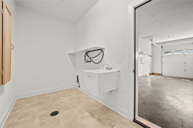 laundry room with a garage, laundry area, and baseboards