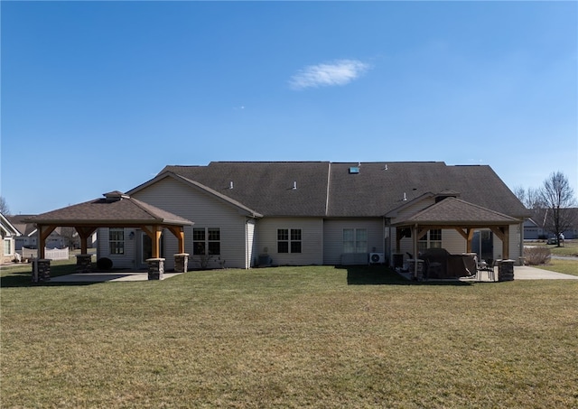 rear view of house with a gazebo, a patio, and a lawn