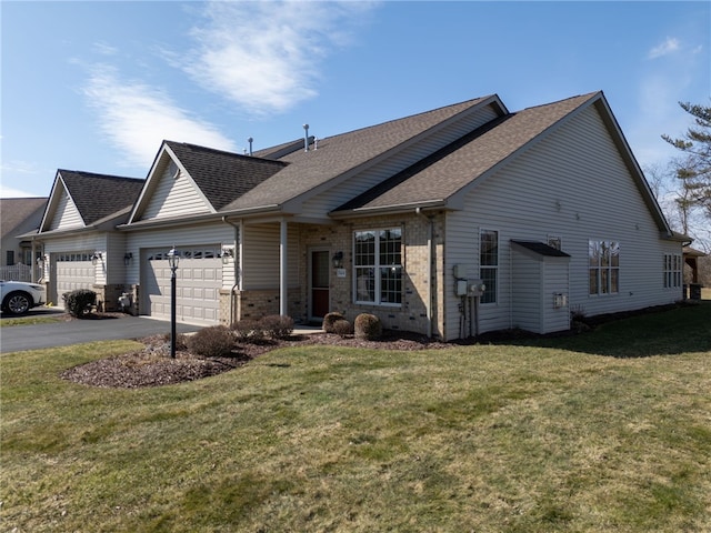 view of front facade with brick siding, roof with shingles, a garage, driveway, and a front lawn