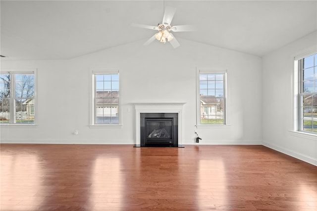 unfurnished living room featuring a wealth of natural light and wood finished floors