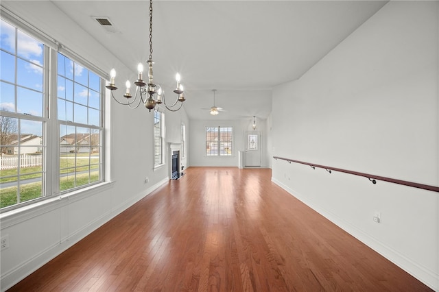 unfurnished living room featuring visible vents, a fireplace, baseboards, and hardwood / wood-style flooring