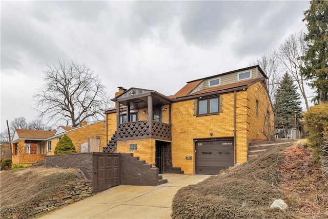 view of front of house with a garage, concrete driveway, and brick siding