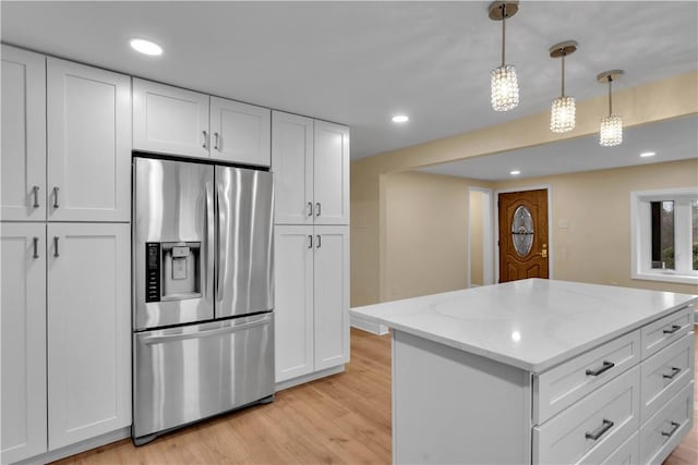 kitchen with light wood-type flooring, white cabinets, stainless steel refrigerator with ice dispenser, and recessed lighting