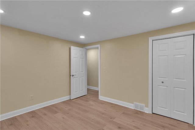 unfurnished bedroom with baseboards, visible vents, light wood-style flooring, a closet, and recessed lighting