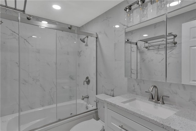 full bathroom featuring tile walls, bath / shower combo with glass door, tasteful backsplash, toilet, and vanity