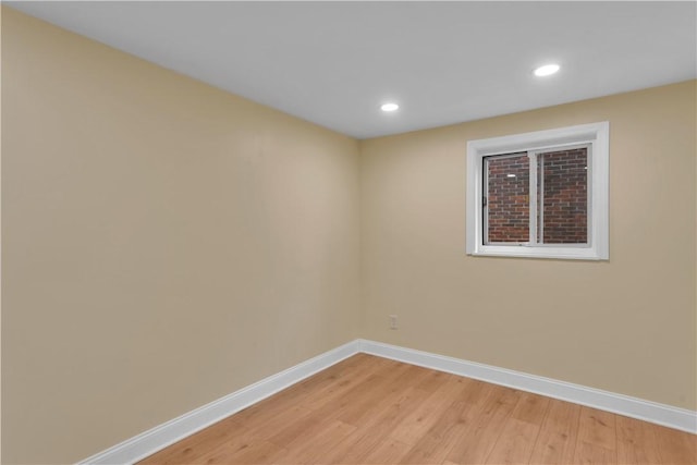 empty room featuring light wood finished floors, baseboards, and recessed lighting