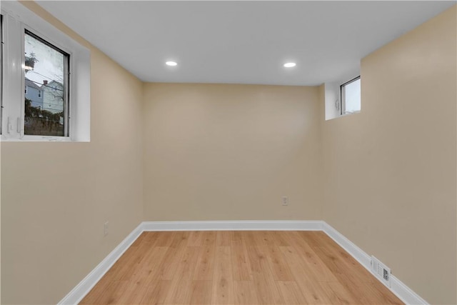 basement featuring light wood finished floors, baseboards, visible vents, and recessed lighting