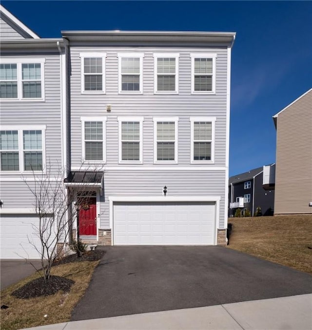 view of property with a garage and aphalt driveway