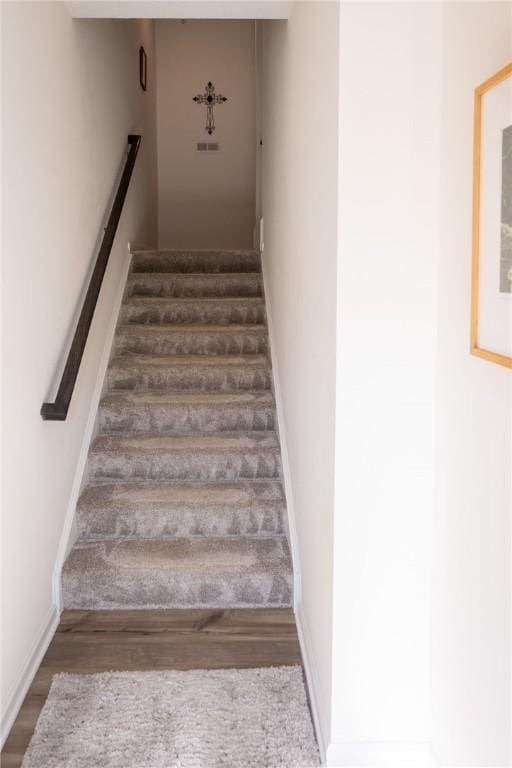 stairs with wood finished floors and baseboards