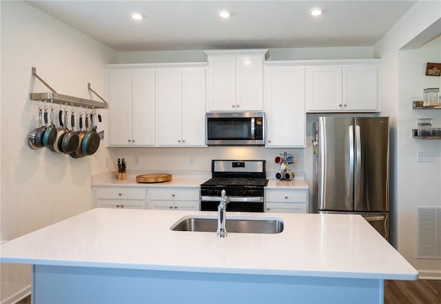 kitchen featuring light countertops, visible vents, appliances with stainless steel finishes, white cabinetry, and a sink