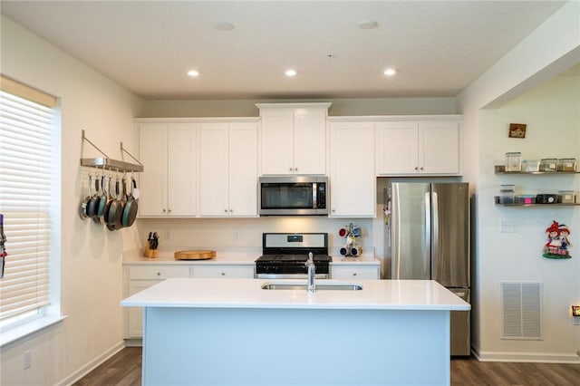 kitchen featuring stainless steel appliances, light countertops, visible vents, white cabinets, and a sink